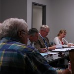 Iowa Western President Dr. Dan Kinney (Center, tan sport jacket) speaks at the meeting held in Atlantic.