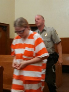 Leatha Kay Slauson enters the courtroom accompanied by Cass County Sheriff Darby McLaren. (Ric Hanson/photo)