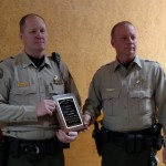 Cass County Sheriff's Deputy Corey Larsen (Left) is presented with a plaque by Sheriff Darby McLaren. 
