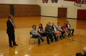Pottawattamie County Sheriff Jeff Danker addresses the 7 students at an assembly Wednesday, who helped their classmates after a bus rollover accident. (Photo from Pott. Co. S/O Facebook page)
