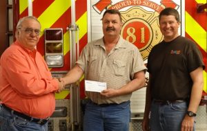 General Manager and President of Walnut Communications, Bruce Heyne presents a check to Fire Chief Paul Ward and Greg Heine on behalf of the Neola Fire Department. 