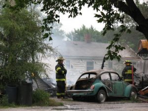 A power line (on the left near the tree) burns moments before showering sparks. (Ric Hanson/photos)